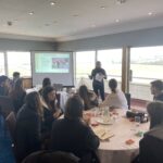 Explore career days at BHA Careers in racing, a photo of a group of people at an explore day, speaking around a table.